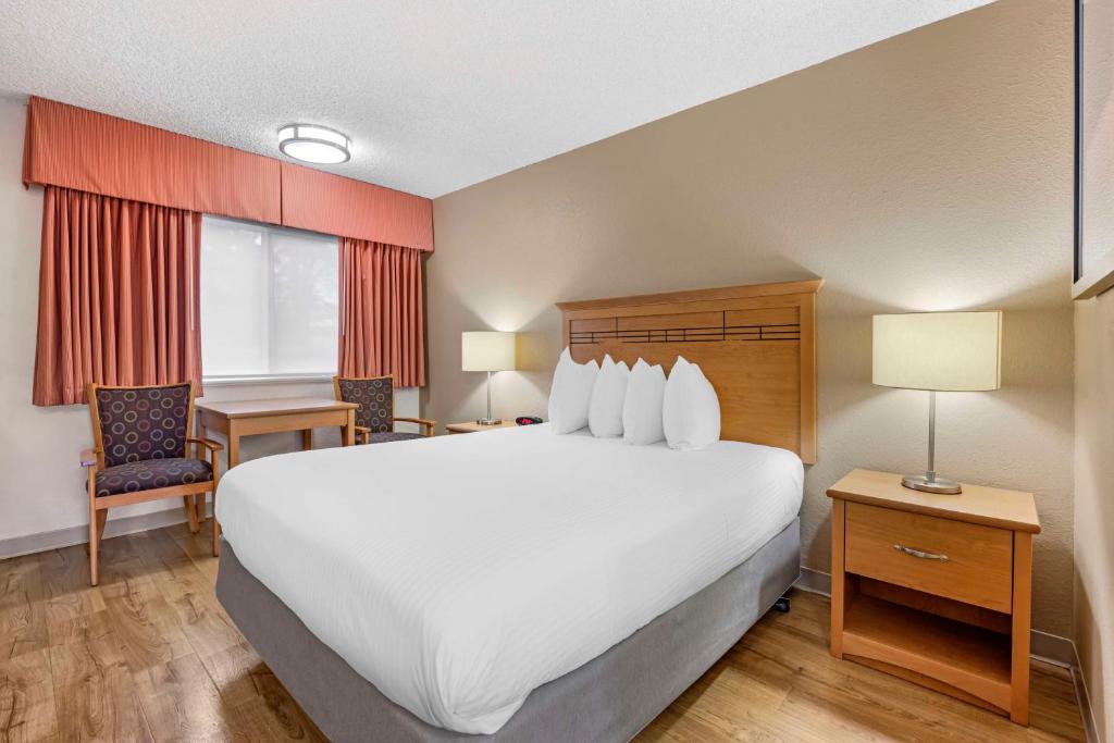 a hotel room with a large white bed and a desk at Best Western Aladdin Inn in Kelso