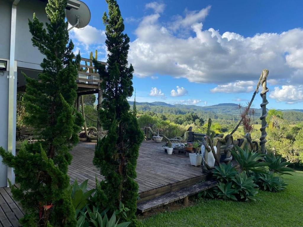 a deck with a view of the mountains from a house at Loft no Morro da Borussia I in Osório
