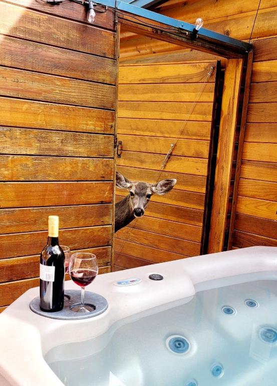 a bottle of wine and a wine glass next to a bath tub at Cowboy's Trail with HotTub, King&QueenBed, in UpperCanyon, Pets welcome in Ruidoso