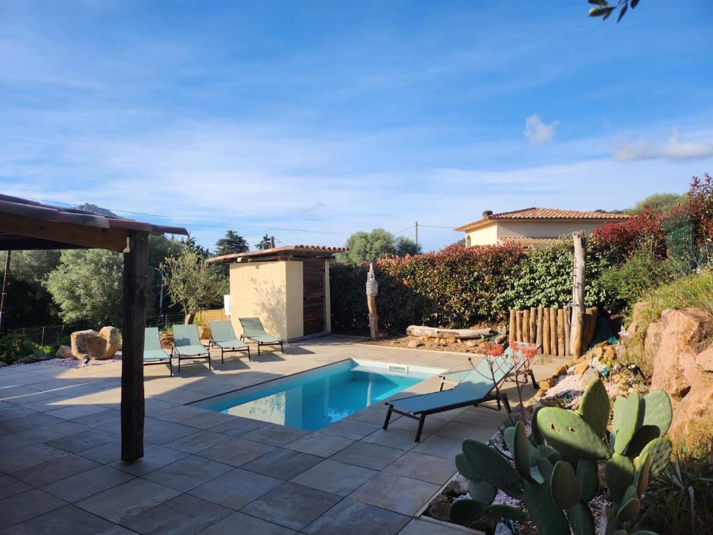 une cour arrière avec une piscine et une maison dans l'établissement A l'Ombra Di l'Alivu, à Figari