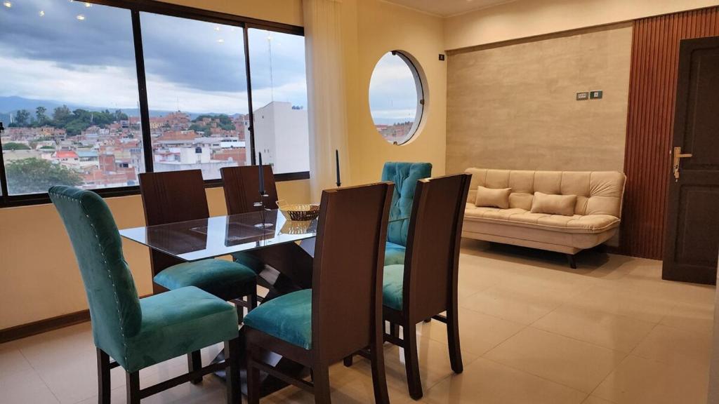 a dining room with a table and chairs and a couch at Beautiful and central apartment in Tarija