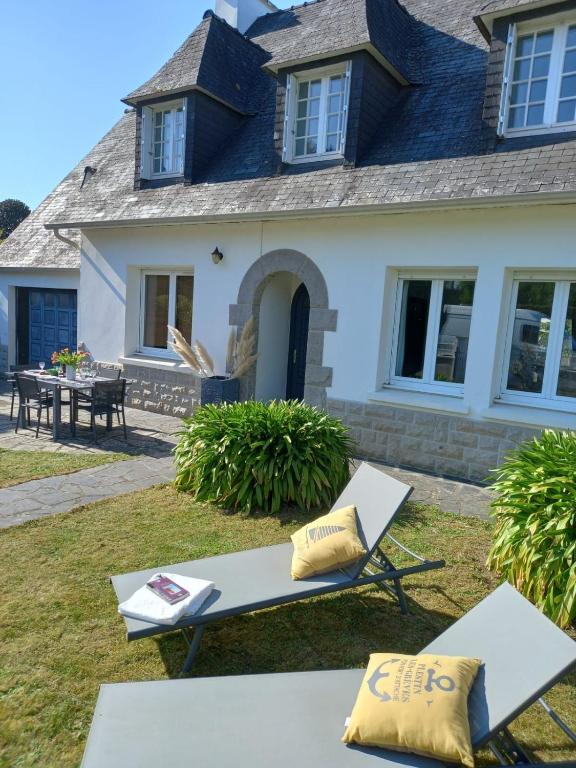 une maison avec deux chaises longues devant elle dans l'établissement La Grande Plage, tout proche des plages, 5 personnes, à Plestin-les-Grèves