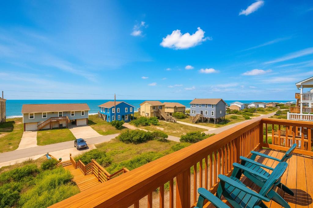 a deck with blue chairs and a view of the ocean at Beachside 4bdrm Emerald Isle in Emerald Isle