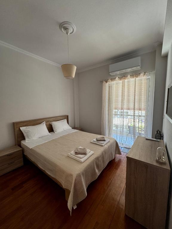 a bedroom with a large bed and a window at Rosie Apartment in Preveza
