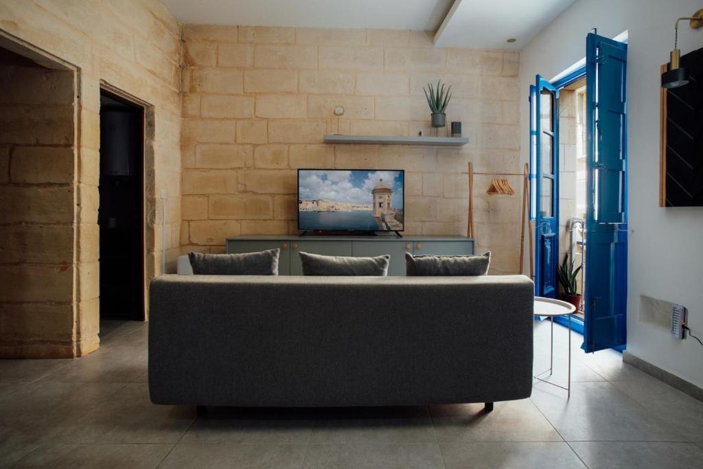 a living room with a couch and a wall at Senglea town house in Senglea