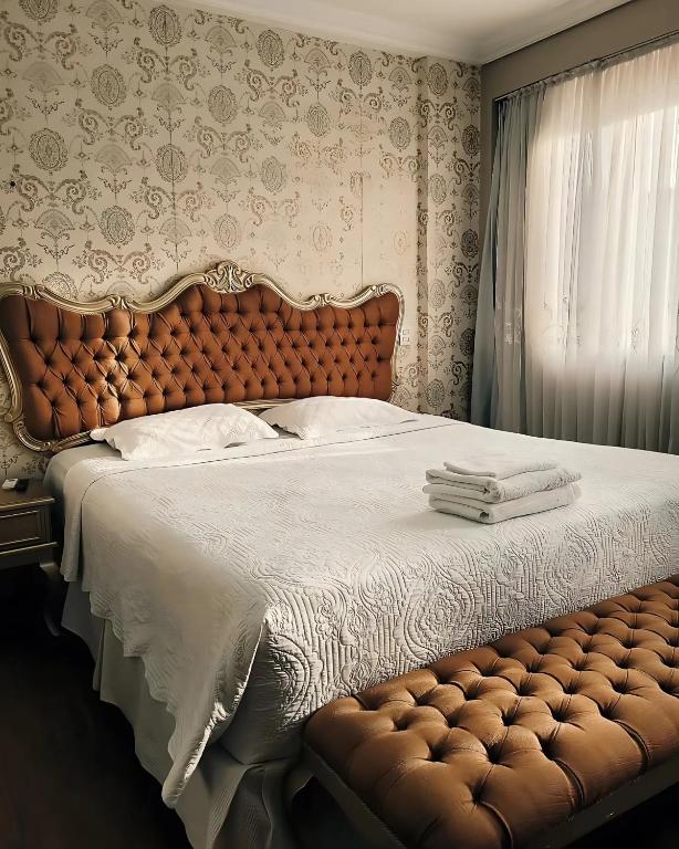 a bedroom with a large bed with a brown headboard at Seringal Hotel in Manaus