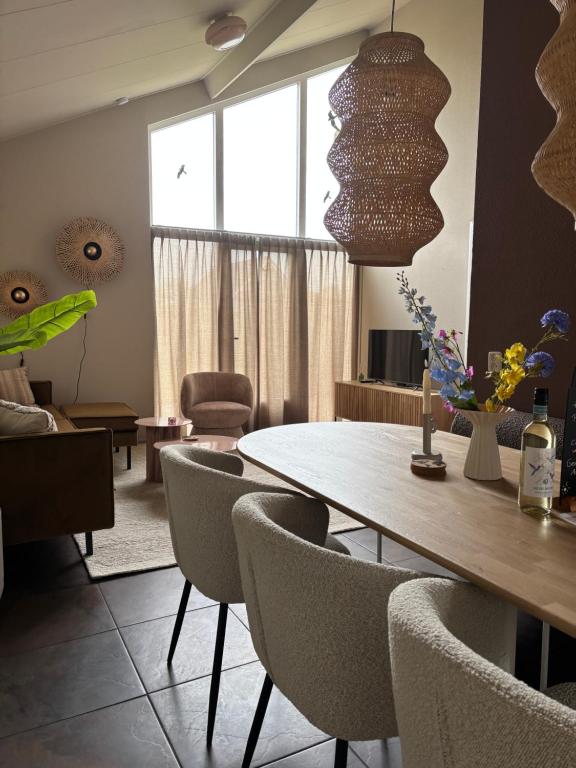 TzummarumにあるVrijstaande en knusse vakantiewoning in Tzummarumのテーブルと椅子のあるダイニングルーム
