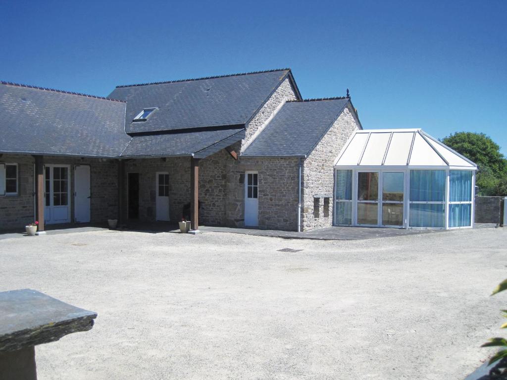 un grand bâtiment en briques avec un grand garage vitré dans l'établissement La Pigacherie aux Pierres Bleues, à Surtainville