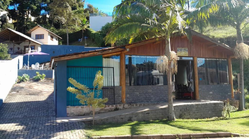 a house with a blue door and a palm tree at Casa da Pedra in Pedra Azul