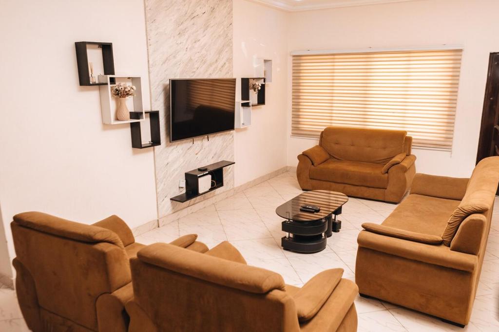 a living room with two chairs and a tv at Executive 2 Bed RealShala Properties-Adjiringanor in Ashalebotwe