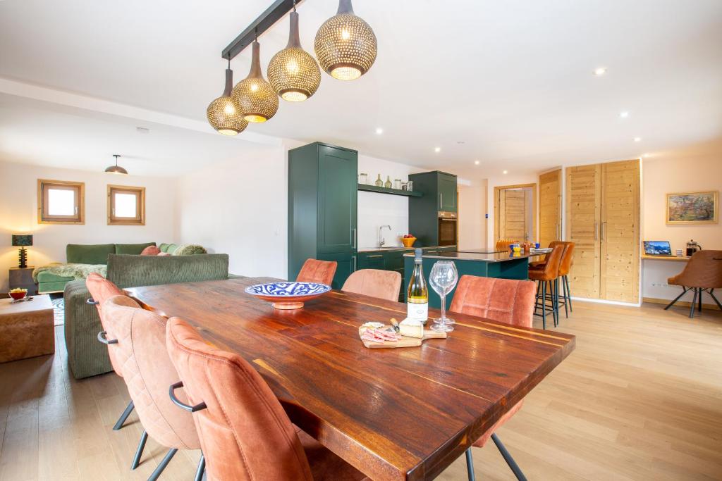 - une salle à manger et un salon avec une table et des chaises en bois dans l'établissement Large, bright and comfortable 3 bedroom apartment, à Morzine