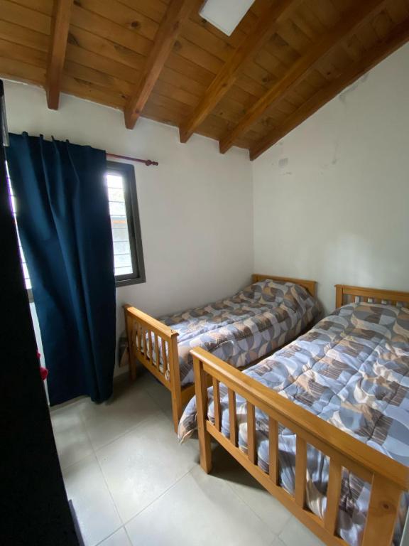 a bedroom with two twin beds and a window at Villa Simona in Santa Rosa de Calamuchita