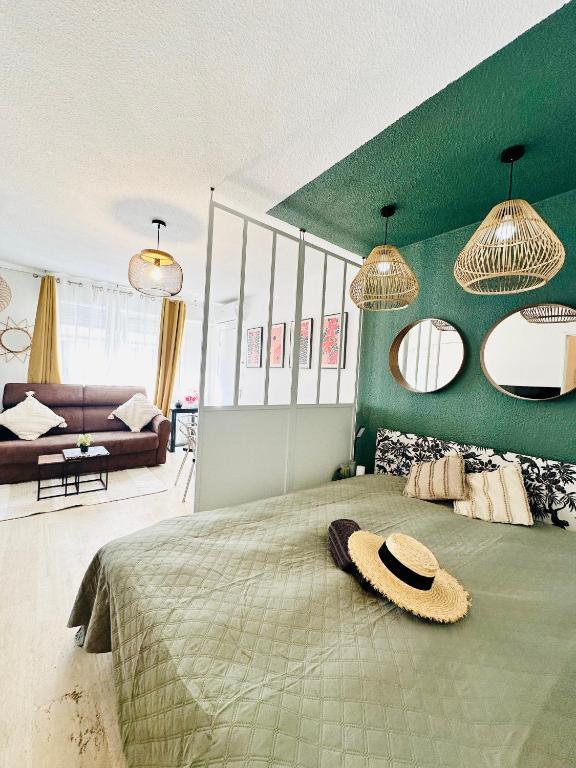- une chambre dotée d'un grand lit avec un chapeau dans l'établissement Studio T1- 2 min des Plages - Golf-Juan - Clim&Wifi, à Vallauris
