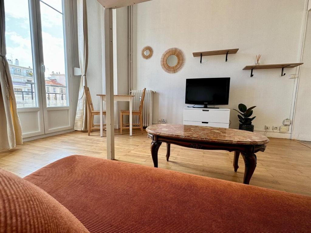 un salon avec une table basse et une télévision dans l'établissement Liberation Cozy Studio in Nice, à Nice