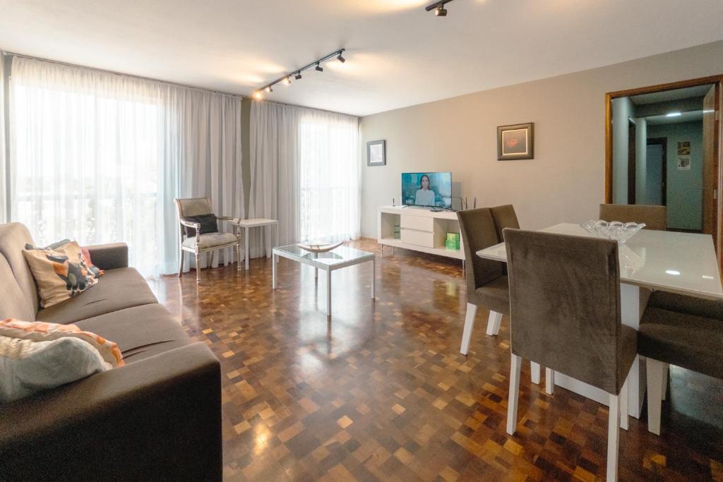 a living room with a couch and a table at Apartamento Central Aconchegante e Espaçoso SQ53 in Maringá