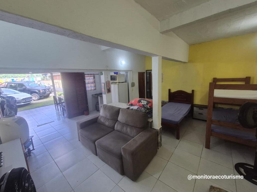 a living room with a couch and a bed at Kitão Completo ao lado da Balsa Bertioga in Bertioga