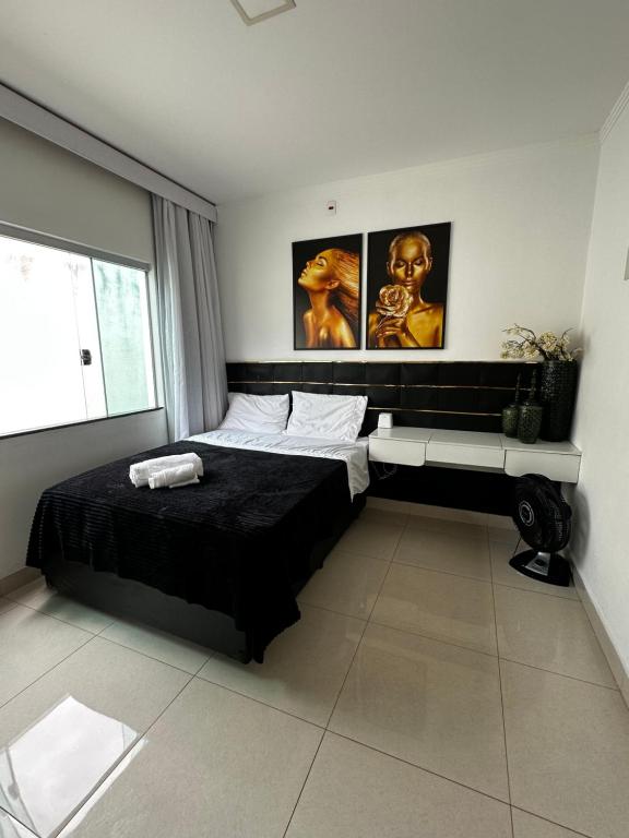a bedroom with a bed and two paintings on the wall at Casa em Capitólio in Capitólio