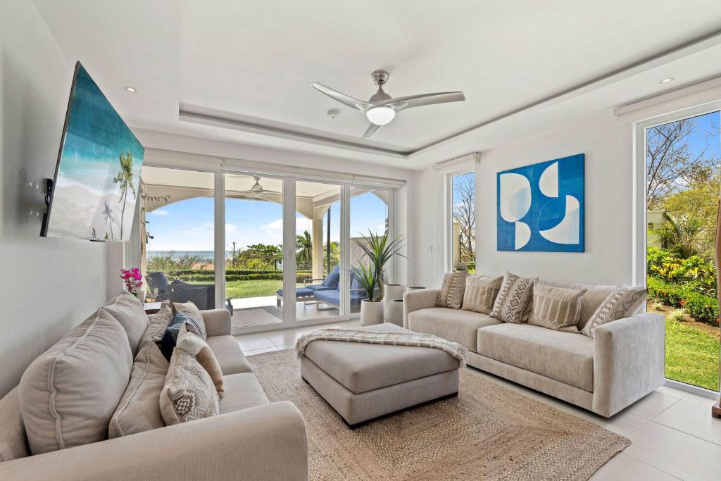 a living room with couches and a ceiling fan at Infinity Pools & Sunsets Over Tamarindo Bay in Tamarindo