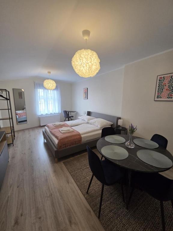 a bedroom with a bed and a table and chairs at Apartamenty Emilia 3 in Gniezno