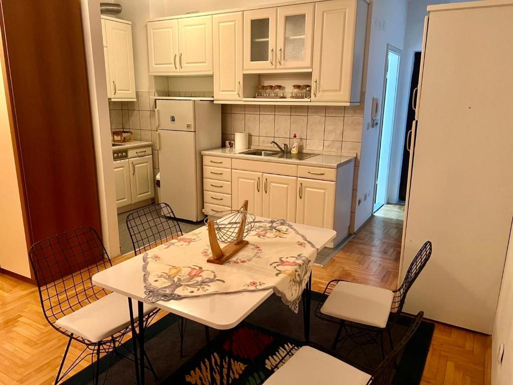 een keuken met een tafel en stoelen en een keuken met witte kasten bij RingRoad Apartment in Ohrid