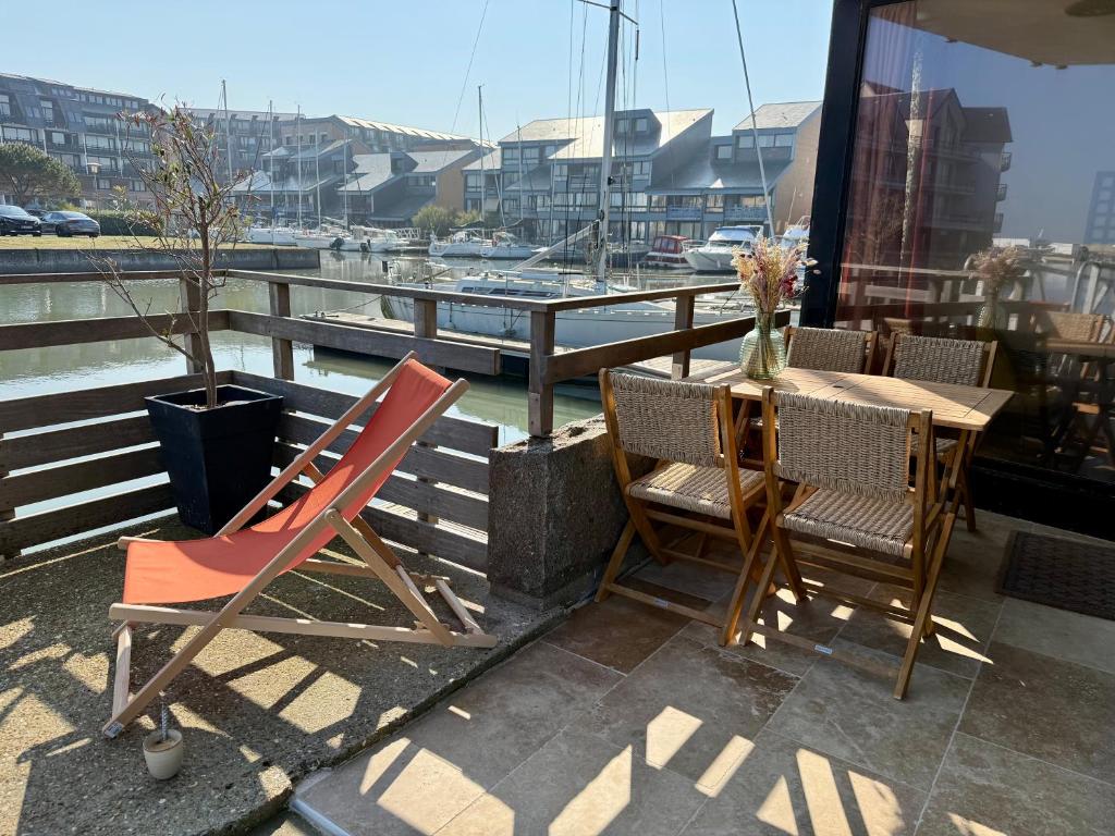 un balcon avec une table et des chaises et un port de plaisance dans l'établissement Ressourcement et bien être en bord de mer, à Deauville
