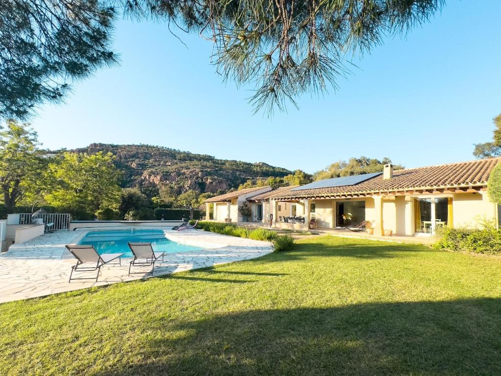 une maison avec une piscine dans une cour dans l'établissement Exclusive Authentic Riviera Villa - Private Pool, Pétanque Court, Panoramic Mediterranean Sea & Estérel Mountain Views, à Saint-Raphaël