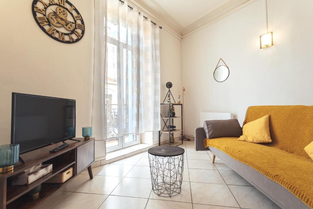 un salon avec un canapé et une télévision dans l'établissement Le Albert 1er appartements tout équipés au coeur de Béziers, à Béziers