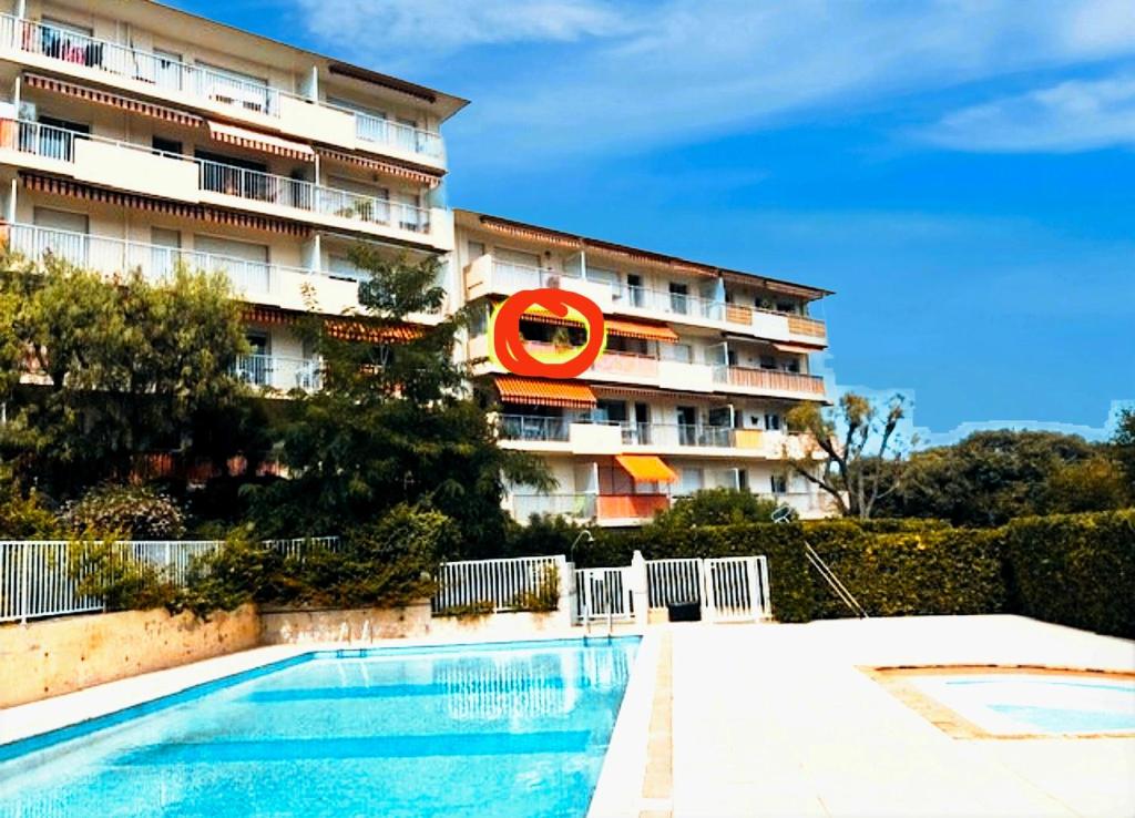 un hôtel avec une piscine devant un immeuble dans l'établissement Studio Piscine Antibes, à Antibes