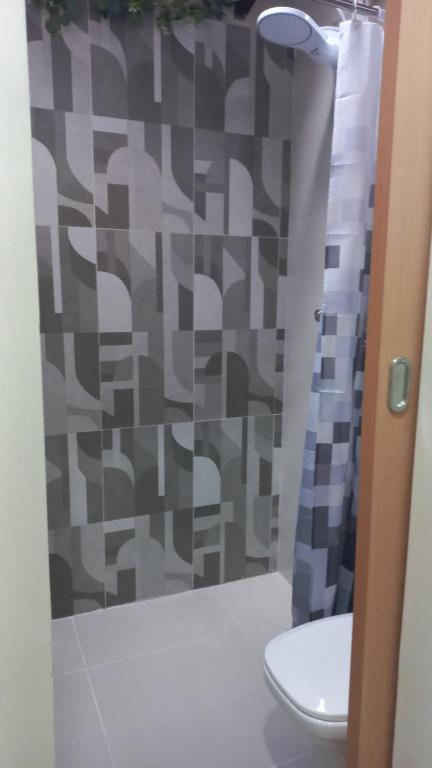 a bathroom with a shower curtain and a toilet at Casinha da Paz in Praia Grande