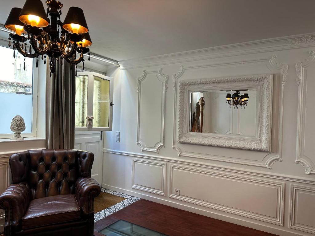 un salon avec une chaise et un miroir dans l'établissement Élégant appartement de ville avec patio, à La Rochelle