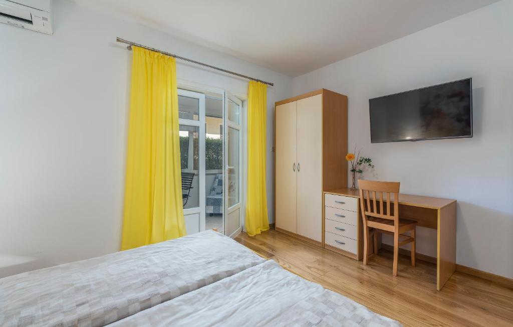 a bedroom with a bed and a desk and yellow curtains at Guesthouse Casa Nova in Poreč