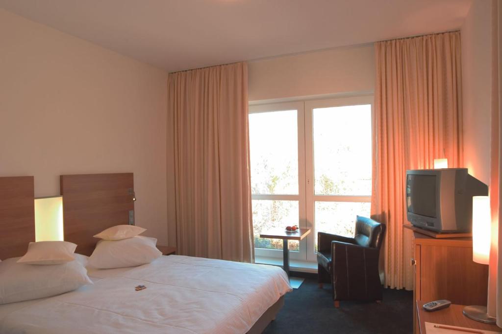 Postel nebo postele na pokoji v ubytování Stadthotel Crailsheim