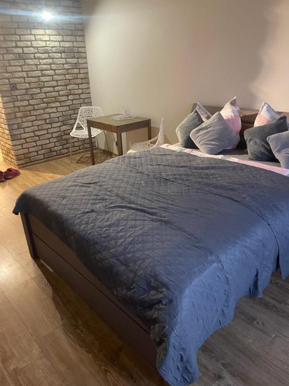 a bed with a blue comforter and pillows on it at studio Szymanowskiego 5 in Szczecin