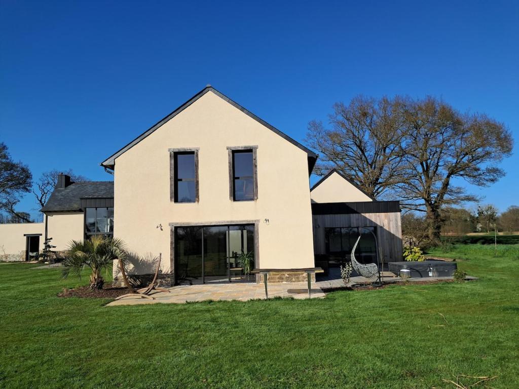 une grande maison blanche sur un champ verdoyant dans l'établissement Au calme à la campagne 13 pers, à La Mézière