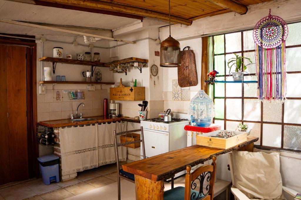 een keuken met een wastafel en een tafel. bij Casita Meraki para 2 personas in Villa Carlos Paz