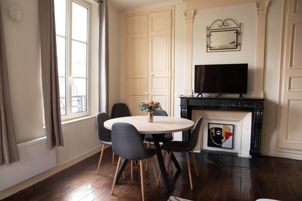 un salon avec une table, des chaises et une télévision dans l'établissement Cathedral Spark, à Troyes