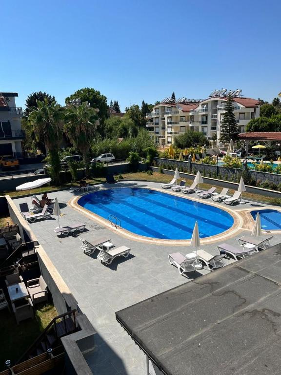 a large swimming pool with lounge chairs at SideByLotus in Side