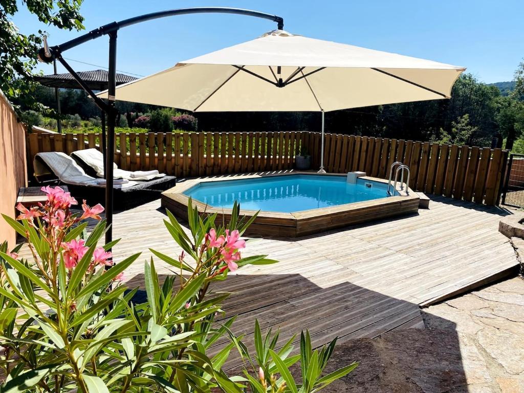 un patio avec un parasol et une piscine dans l'établissement Maison de vacances, à Cogolin