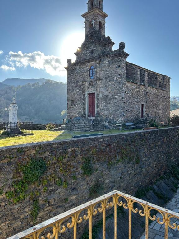 an old building with a tower on top of a wall at Maison typique de village in Sorbo-Ocagnano