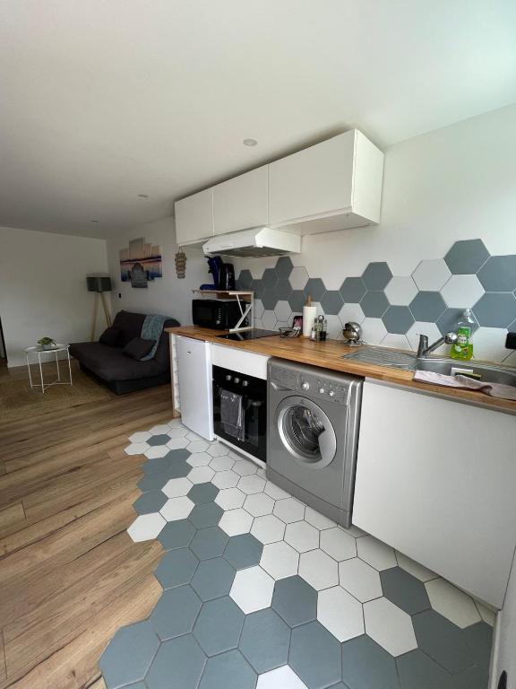 une cuisine avec une machine à laver à l'étage dans l'établissement Appartement neuf 1 Chambre en rez de jardin avec, à Lovagny