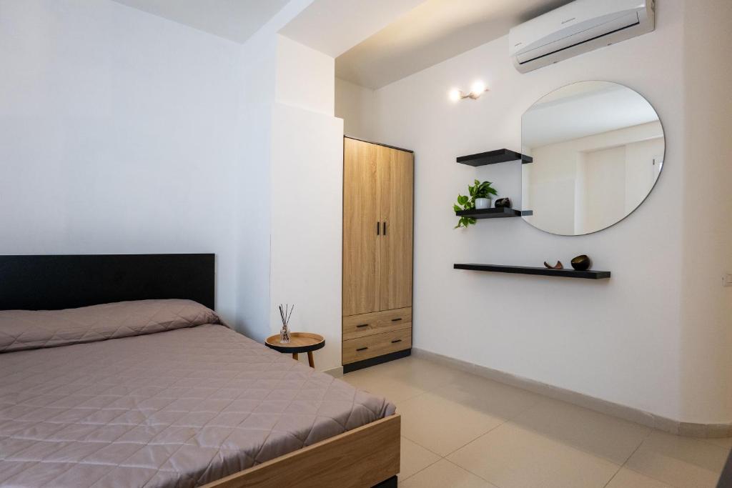 un dormitorio con una cama y un espejo en Antonelli Apartment, en Terracina