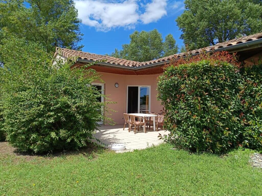 Cette petite maison dispose d'une terrasse avec une table et des chaises. dans l'établissement Au bord du Lac, à Châteauneuf-sur-Isère