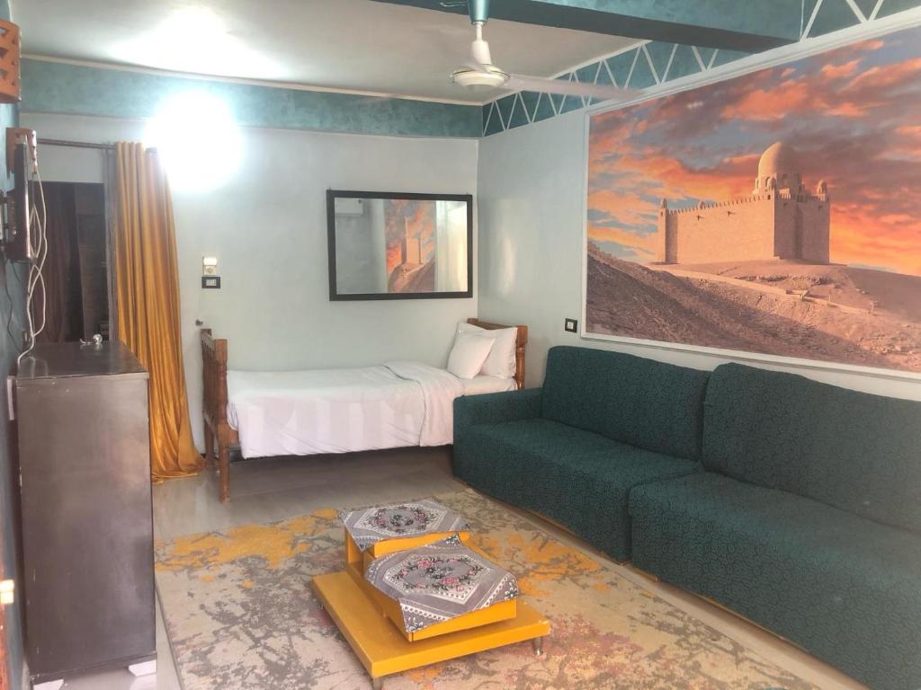 un soggiorno con divano e letto di HAWATY NUBA DWeLL a Nag` el-Ramla