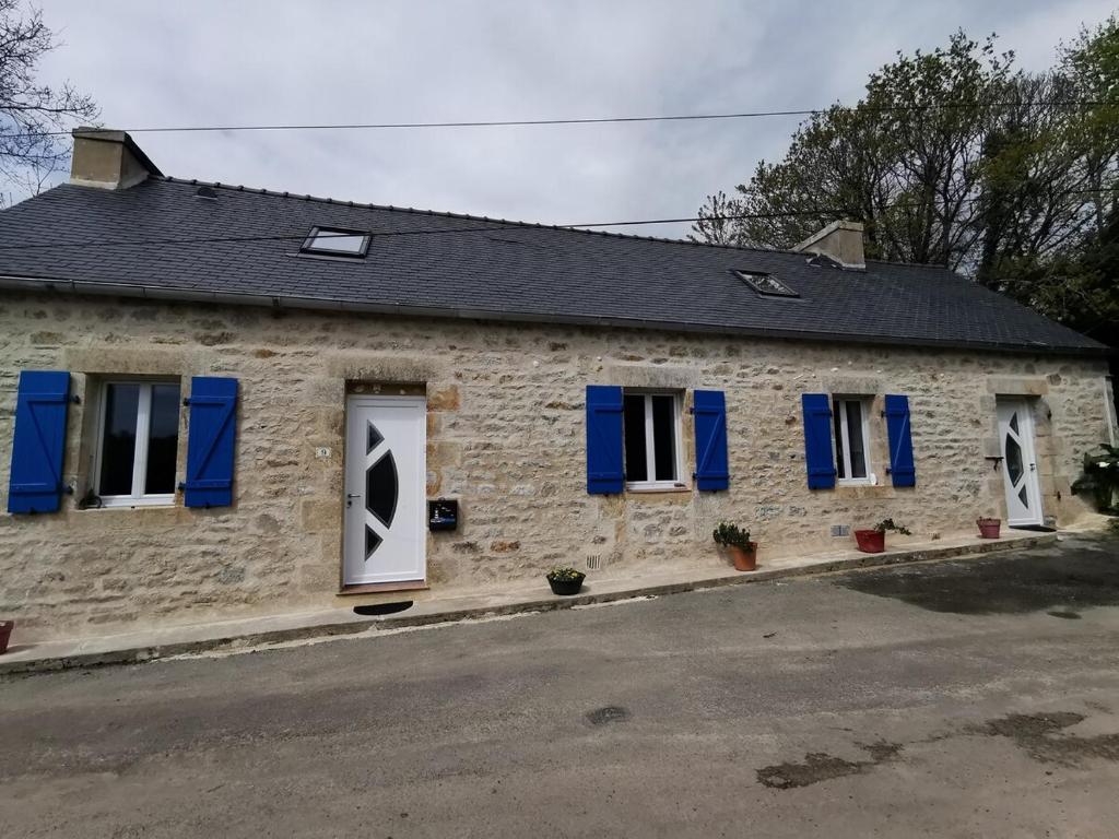 - un bâtiment en pierre avec volets bleus dans l'établissement Au repos du Dourmeur, à Saint-Évarzec