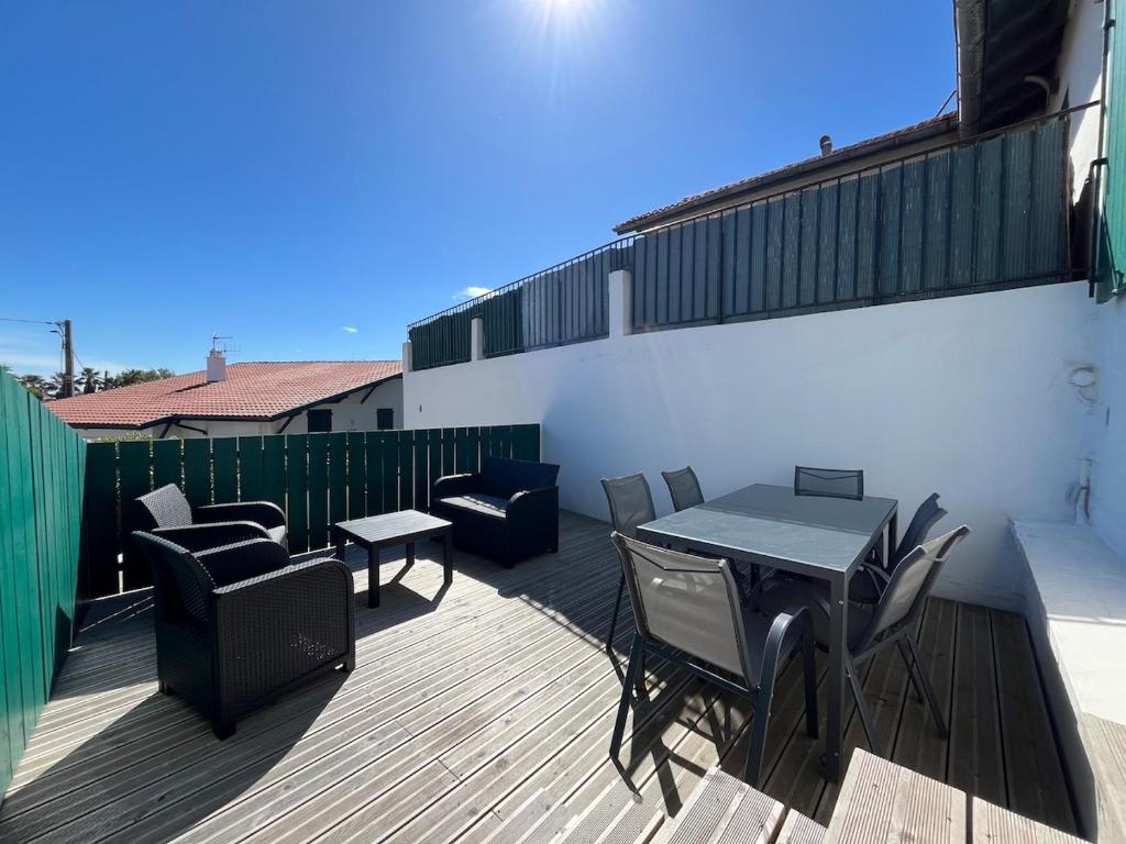 un patio avec une table et des chaises sur une terrasse dans l'établissement Modern bright flat with outside terrace, à Biarritz