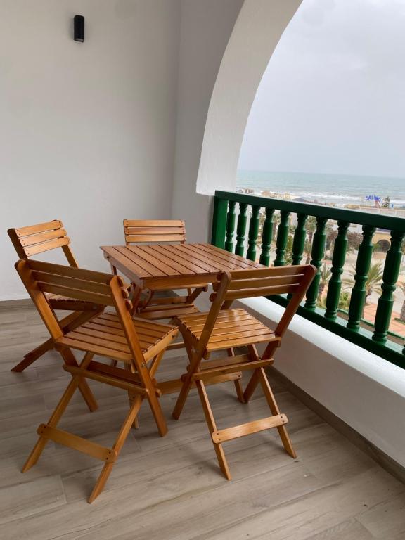 deux chaises et une table et un banc en bois sur un balcon dans l'établissement Suite d'Hôtel vue sur mer, à Yasmine