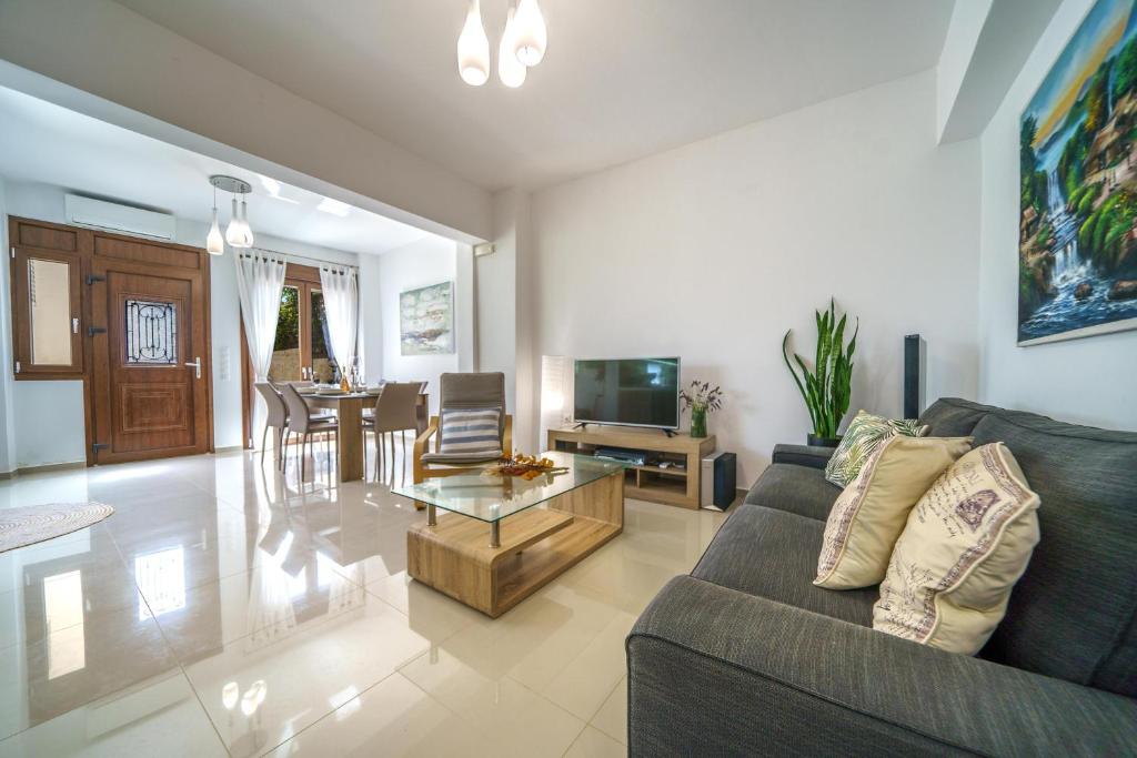 a living room with a couch and a table at Stylish home - comfortable holidays near the beach. in Panormos Rethymno