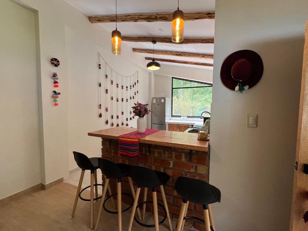 a kitchen with a bar with stools around it at Q'inti Apartment in Lamay