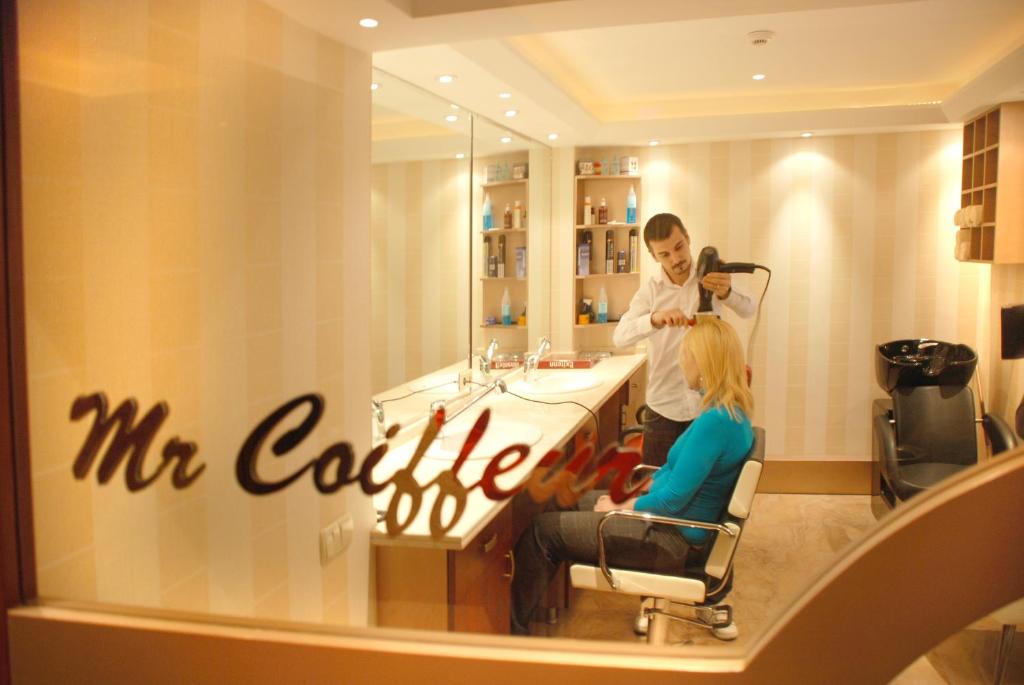 a man cutting a girls hair in a salon at Mosaic Hotel Old City -Special Category in Istanbul