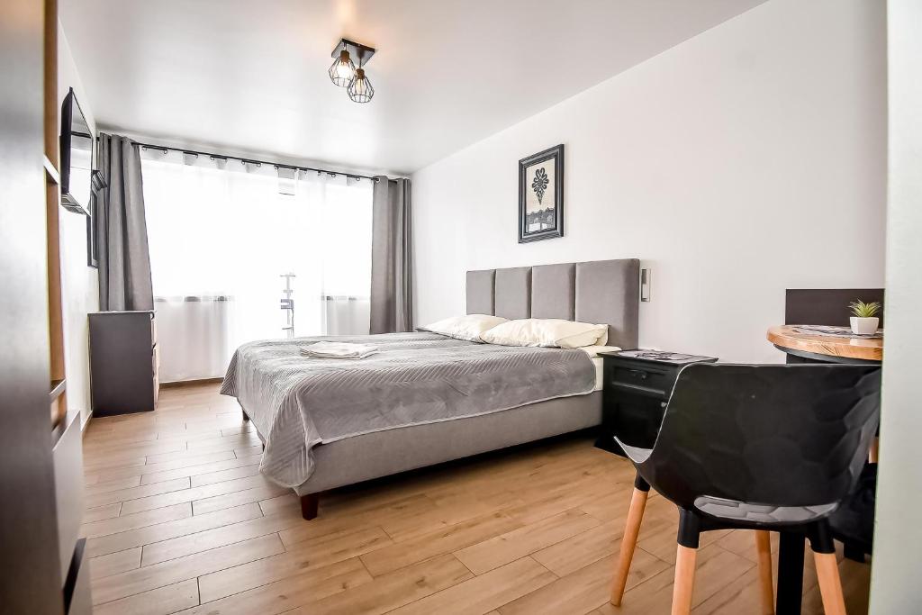 a bedroom with a bed and a desk and a chair at Willa Góry A - Noclegi z widokiem na góry śniadaniami i sauna in Bukowina Tatrzańska